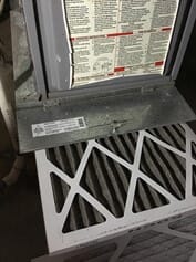 Dirty air filter being pulled out of a furnace that is not blowing hot air